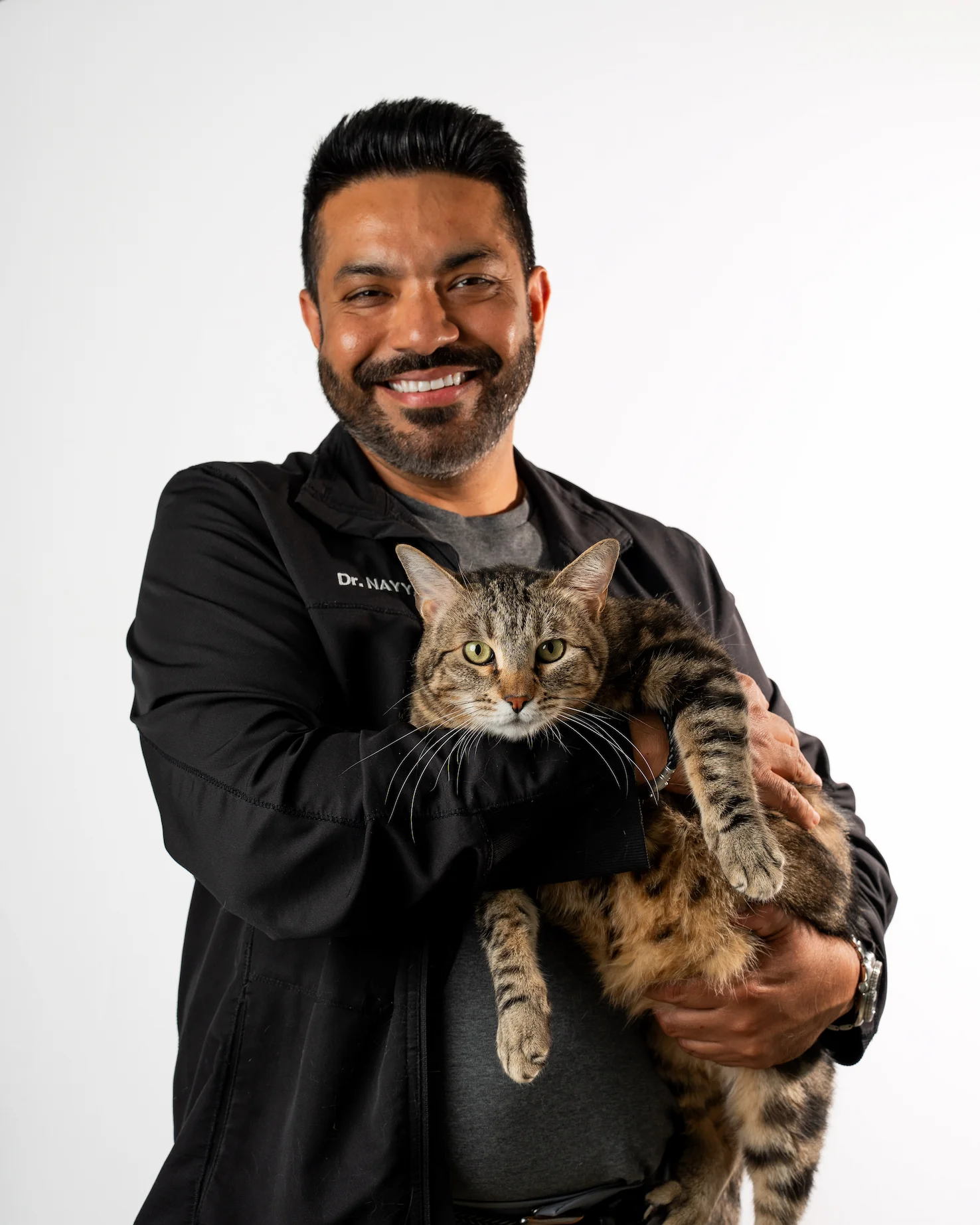 Dr. Nayyar holding a tabby cat